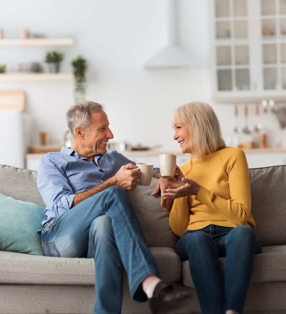 Cheerful Mature Couple Drinking Tea And Talking Sitting At Home Immobilienmakler Bremen - Glückliche Kunden